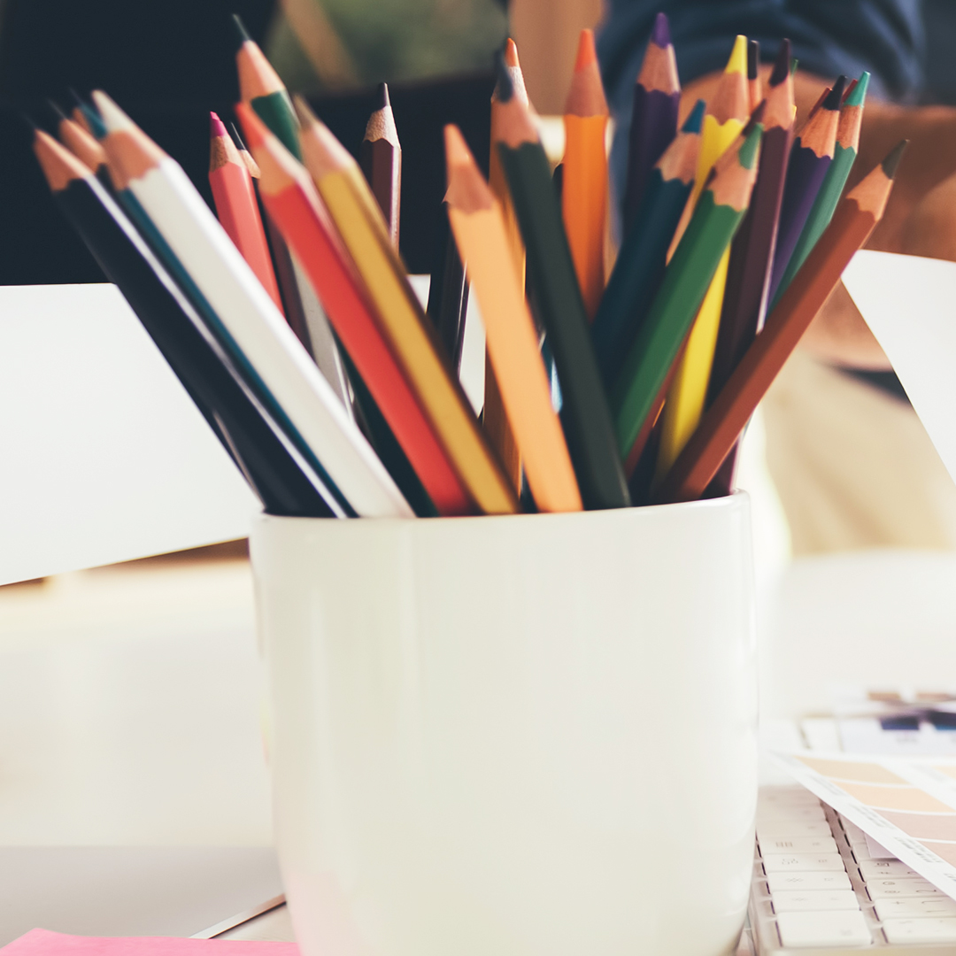 Graphic designer working at his desk and is choosing colors toge